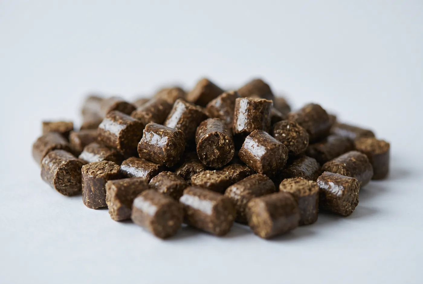 Large dark ruminant feed pellets with molasses sheen